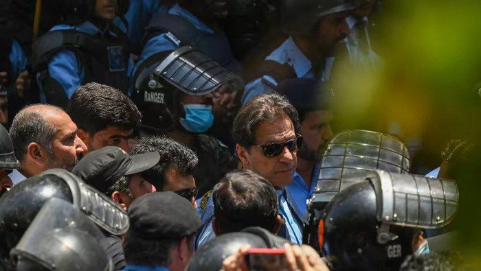 Policemen escort Pakistans former Prime Minister Imran Khan (centre) as he arrives at the high court in Islamabad on May 12, 2023. (Photo: AFP/Aamir Qureshi)