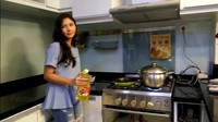 Kemudian dibarengi dengan menggoreng ikan asin. Jessica Mila hendak menuangkan minyak goreng di wajan anti lengkep berwarna hitam kuning miliknya. Foto: YouTube Jessica Mila