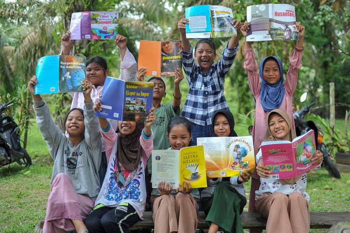 Salah seorang donatur (tengah belakang) mendongengkan cerita usai menyerahkan buku kepada anak-anak Taman Baco Atap Rumbe di Jambi Tulo, Muaro Jambi, Jambi, Minggu (14/5/2023). Penyerahan buku dari berbagai kalangan untuk taman baca desa yang didirikan secara swadaya itu dilakukan dalam rangka menyambut Hari Buku Nasional yang jatuh pada 17 Mei besok. ANTARA FOTO/Wahdi Septiawan/foc.