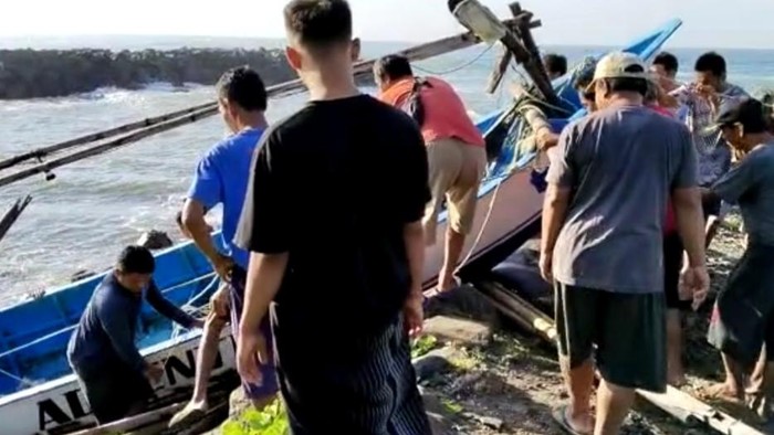 Nelayan mendaratkan perahu yang rusak akibat bertabrakan di pelabuhan nelayan Pamayangsari Tasikmalaya.
