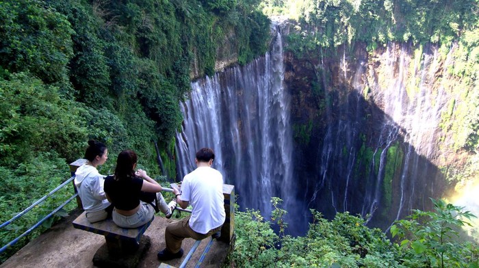 Pengunjung menikmati pemandangan air terjun Coban Sewu di Sidomulyo, Pronojiwo, Lumajang, Jawa Timur, Sabtu (13/5/2023). Air terjun setinggi 120 meter menyerupai tirai yang berhulu di Gunung Semeru itu merupakan salah satu wisata alam yang sering dikunjungi wisatawan. ANTARA FOTO/Budi Candra Setya/aww.
