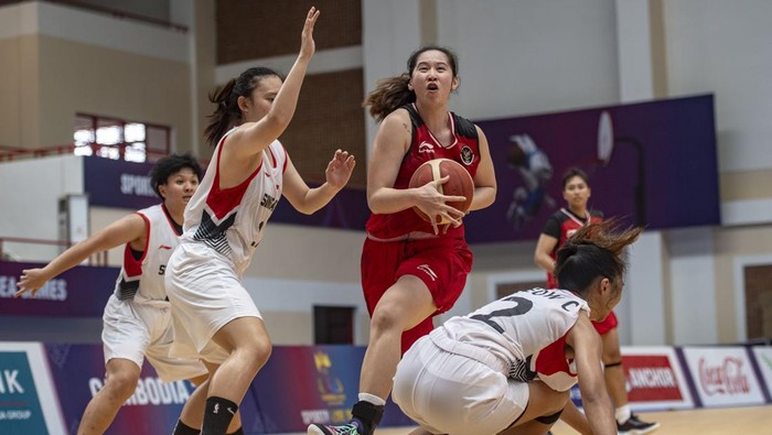 Pebasket putri Indonesia Priscilla Karen (tengah) mencoba melewati pebasket Singapura Lim Lek K (kiri) dan Yeow Jia Jc (kanan) pada pertandingan Basket 5X5 SEA Games 2023 di Elephant Hall 2, Morodok Techo Indoor Sports Center, Phnom Penh, Kamboja, Minggu (14/5/2023). Tim bola basket putri Indonesia berhasil mendapatkan medali emas usai mengalahkan Singapura dengan skor 86-39. ANTARA FOTO/Muhammad Adimaja/foc.