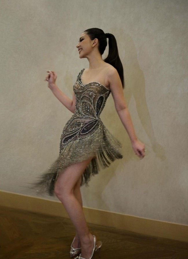 Gaun hitam yang dikenakannya memiliki siluet tegas dan struktural, namun taburan payet dan rumbai berkilauan memberi kesan fluid bak air menari. Foto: Instagram