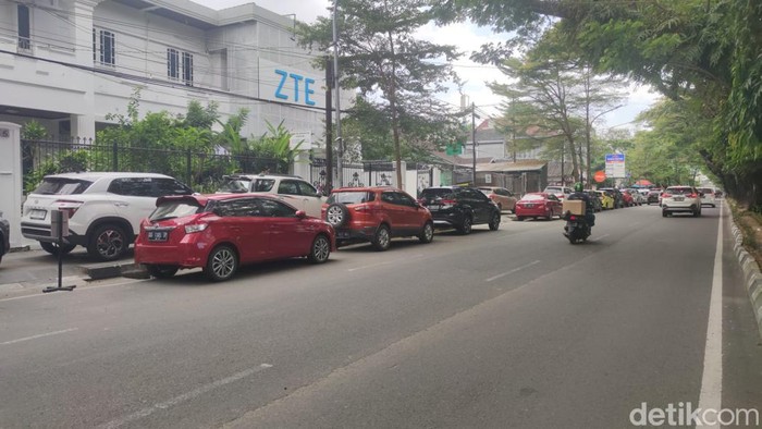 Kendaraan parkir di bahu Jalan Hertasning, Makassar.