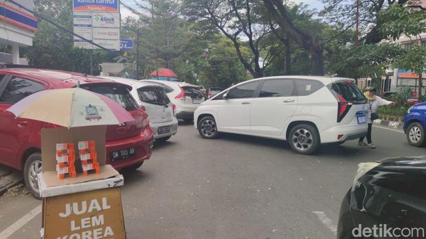 Kendaraan parkir di bahu Jalan Hertasning, Makassar.