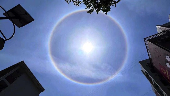 Penampakan Fenomena Halo Matahari di Langit China Fenomena matahari yang tampak seperti dilingkari cincin atau halo matahari muncul di langit Hubei, China. Ini penampakannya.