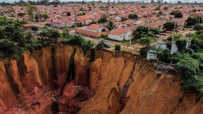 Potret Ngerinya Tanah Terbelah di Brasil Aerial view of erosions in Buriticupu, Maranhao state, Brazil, taken on April 21, 2023. - An unusual phenomenon caused by a lack of urban planning and aggressive deforestation is driving Buriticupu, a small town in Brazil's impoverished northeastern state of Maranhao, towards gradual collapse, experts say. The city of 70,000 is suffering from the advance of