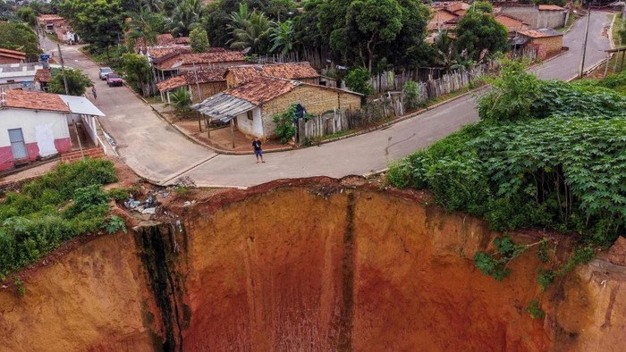 Potret Ngerinya Tanah Terbelah di Brasil Aerial view of erosions in Buriticupu, Maranhao state, Brazil, taken on April 21, 2023. - An unusual phenomenon caused by a lack of urban planning and aggressive deforestation is driving Buriticupu, a small town in Brazil's impoverished northeastern state of Maranhao, towards gradual collapse, experts say. The city of 70,000 is suffering from the advance of