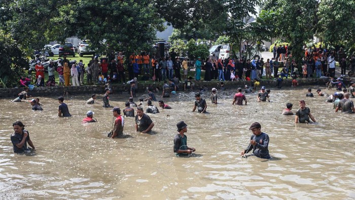 Potret Tradisi Ngubek Empang Jelang Lebaran Depok 2023 Foto udara sejumlah warga menangkap ikan saat tradisi ngubek empang di Bojongsari, Depok, Jawa Barat, Senin (15/5/2023). Ngubek empang merupakan tradisi warga Betawi Depok yang dilakukan orang tua zaman dulu sebelum Lebaran yang saat ini masih dilestarikan oleh warga setempat. ANTARA FOTO/Asprilla Dwi Adha/tom.