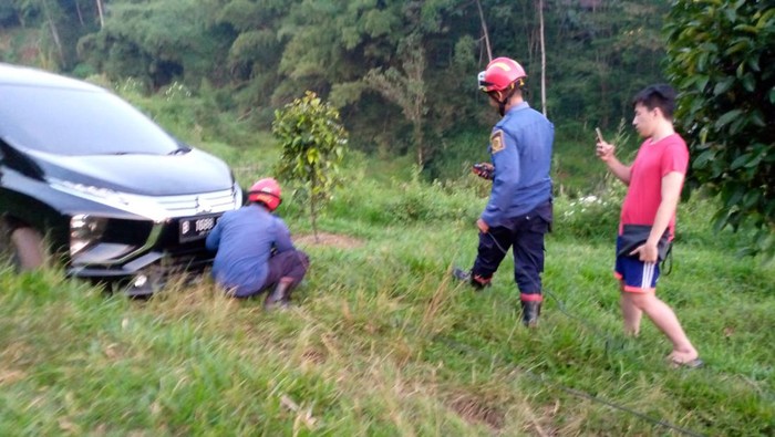 Tim rescue damkar mengevakuasi mobil wisatawan asal Jakarta yang tersesat hingga terjebak di perbukitan berlumpur di kawasan Puncak, Cisarua, Bogor. (dok Istimewa)