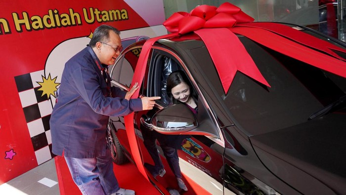 Pemenang utama Program Poin Festival 2022 (tengah) bersama Vice President Consumer Sales Area Jawa Bali Telkomsel Riny Novitriyanti (kiri) dan Vice President Postpaid Consumer, International Roaming and Interconnect Telkomsel Bernadus W. Wijayanto (kanan) saat penyerahan hadiah 1 unit Mobil Mercedes-Benz C200 di Semarang, Senin (15/5).
