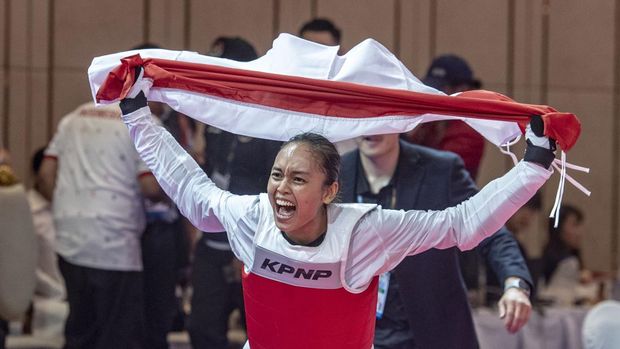Atlet Taekwondo Indonesia Megawati Tamesti Maheswari (kiri) membawa bendera merah putih bersama pelatih Taekwondo Indonesia Kim Seung-ill (kanan) usai menang melawan atlet Taekwondo Thailand Chutikan Jongkolrattanawattana pada pertandingan taekwondo 'under' 53 kilogram putri SEA Games 2023, di Chory Changvar International Convention and Exibhition Center, Phnom Penh, Kamboja, Senin (15/5/2023). Megawati Tamesti Maheswari berhasil meraih medali emas usai mengalahkan atlet taekwondo Thailand dengan skor 2-1, sementara medali perak diraih atlet taekwondo Thailand Chutikan Jongkolrattanawattana serta medali perunggu diraih atlet taekwondo Filipina Baby Jessica Canabal dan atlet taekwondo Kamboja Mam Julie. ANTARA FOTO/Muhammad Adimaja/hp.