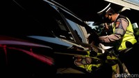 Pengguna mobil yang menerobos traffic light juga kena tilang manual polisi.