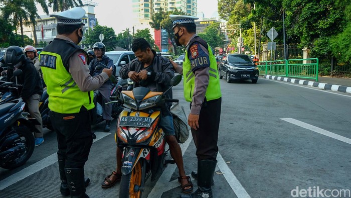 Polda Metro Jaya kembali memberlakulan tilang manual. Pengendara bandel seperti pemotor tidak memakai helm turut ditilang.