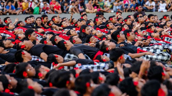 Balinese students dancers raise their arms and chant in a frenzied chorus during the National Education Day in Klungkung, Bali, Indonesia, May 16, 2023. About 1,000 students danced on the field in a colossal show, and their chants of ''cak-cak'' took the place of musical instruments during the performance. The Kecak is an epic tale from the Ramayana, a Hindu holy book, that dramatizes the eternal conflict between good and evil. (Photo by Garry Lotulung/NurPhoto via Getty Images)