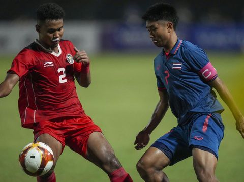 Indonesia's Amiruddin Bagas, left, battles for the ball against Thailand's Channarong Promsrikaew during their men's final soccer match at the 32nd Southeast Asian Games in Phnom Penh, Cambodia, Tuesday, May 16, 2023. (AP Photo/Tatan Syuflana)