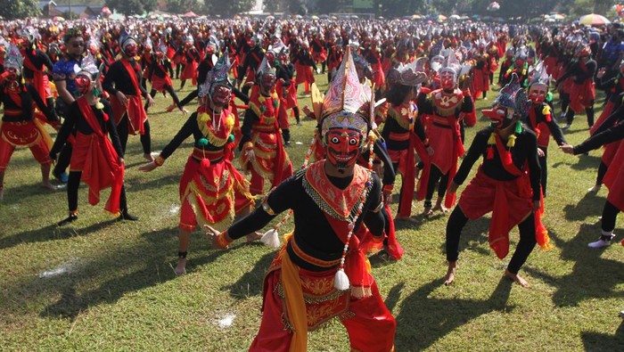 Pelajar membawakan tari topeng Bapang secara massal dalam kegiatan Gebyar Topeng Malangan di lapangan Pakisaji, Malang, Jawa Timur, Rabu (17/5/2023). Kegiatan kirab dan tari topeng Bapang massal tersebut diikuti 2.023 siswa SD, SMP serta sejumlah sanggar tari sebagai upaya regenerasi sekaligus menanamkan rasa cinta terhadap warisan budaya tari tradisional topeng Malangan.