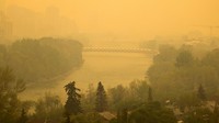 Asap kuning terlihat akibat kebakaran hutan di pusat kota Calgary, Alberta, Kanada, Selasa (16/5/2023).  