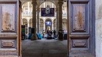 Penampakan dari pintu sejumlah mahasiswa berkumpul di halaman rektorat Universitas Turin, Senin (15/3/2023). Mereka mendirikan tenda di bawah arcde halaman rektorat.