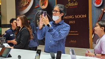 Seorang pengunjung menjajal kemampuan kamera Oppo Find N2 Flip. Foto: Adi Fida Rahman/detikINET