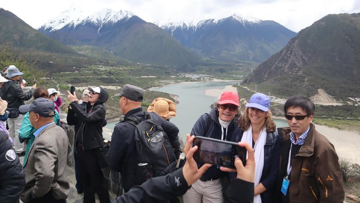 Sejumlah wisatawan berpose dengan latar belakang pemandangan Yarlung Zangbo Grand Canyon di Kabupaten Nyingchi, Daerah Otononomi Tibet, China, Selasa (16/5/2023). Objek wisata di atas ketinggian 4.000 meter dari permukaan laut itu tetap ramai pengunjung meskipun bukan hari libur. (ANTARA FOTO/M. Irfan Ilmie)/foc.