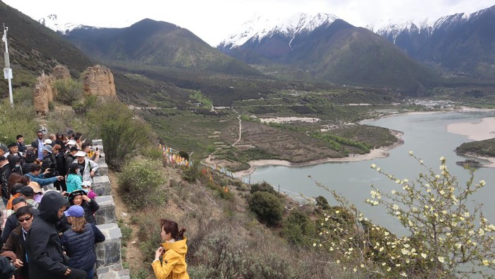 Sejumlah wisatawan berpose dengan latar belakang pemandangan Yarlung Zangbo Grand Canyon di Kabupaten Nyingchi, Daerah Otononomi Tibet, China, Selasa (16/5/2023). Objek wisata di atas ketinggian 4.000 meter dari permukaan laut itu tetap ramai pengunjung meskipun bukan hari libur. (ANTARA FOTO/M. Irfan Ilmie)/foc.
