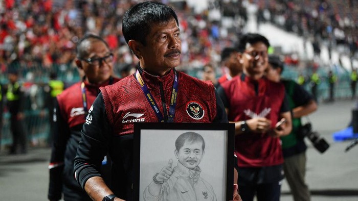 Indonesias coach Indra Sjafri holds a portrait of himself after beating Thailand in the mens football final match during the 32nd Southeast Asian Games (SEA Games) in Phnom Penh on May 16, 2023. (Photo by Nhac NGUYEN / AFP) (Photo by NHAC NGUYEN/AFP via Getty Images)
