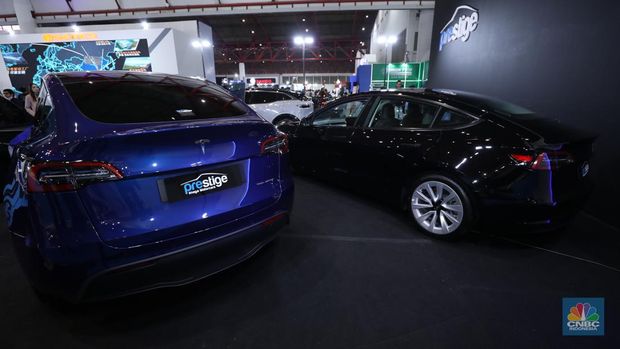 Seorang pegawai membersihkan mobil listrik Tesla yang dipajang dalam pameran Periklindo Electric Vehicle Show (PEVS) di Ji Expo Kemayoran pada (17/5/2023). (CNBC Indonesia/Tri Susilo)