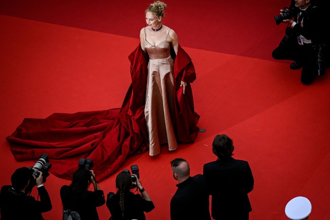 Uma Thurman membawa keglamoran dalam balutan gaun Dior dan luaran merah nan dramatis. Tidak ketinggalan choker mewah dari Chopard. (Foto: PATRICIA DE MELO MOREIRA/AFP via Getty Images)