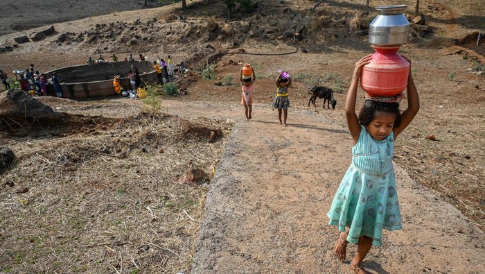 Usaha Wanita di India Dapatkan Air Bersih di Tengah Kekeringan Women carry pitchers full of water which they have collected from a dry well, at Koli pada village in the western Indian state of Maharashtra, on May 16, 2023. Despite being surrounded by large dams, such as, Bhatsa, Tansa and Vaitarna, the residents of the area suffer from severe shortage of water during summer season as the wells dry up very quickly. So, the local administrative body provides water tankers that fill the wells with water everyday.
(Photo by Sankhadeep Banerjee/NurPhoto via Getty Images)