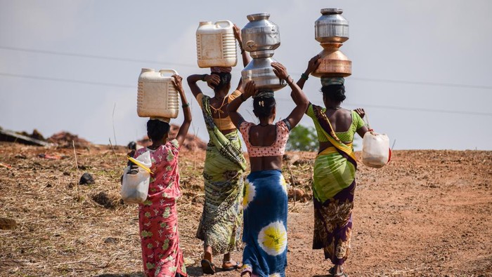 Women carry pitchers full of water which they have collected from a dry well, at Koli pada village in the western Indian state of Maharashtra, on May 16, 2023. Despite being surrounded by large dams, such as, Bhatsa, Tansa and Vaitarna, the residents of the area suffer from severe shortage of water during summer season as the wells dry up very quickly. So, the local administrative body provides water tankers that fill the wells with water everyday. 
 (Photo by Sankhadeep Banerjee/NurPhoto via Getty Images)