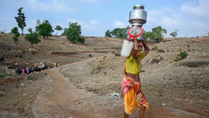 Women carry pitchers full of water which they have collected from a dry well, at Koli pada village in the western Indian state of Maharashtra, on May 16, 2023. Despite being surrounded by large dams, such as, Bhatsa, Tansa and Vaitarna, the residents of the area suffer from severe shortage of water during summer season as the wells dry up very quickly. So, the local administrative body provides water tankers that fill the wells with water everyday. 
 (Photo by Sankhadeep Banerjee/NurPhoto via Getty Images)