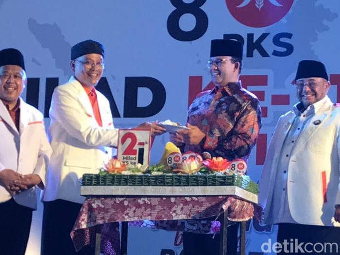 Anies Baswedan menerima potongan tumpeng saat Milad PKS di Jogja, Kamis (17/5/2023).
