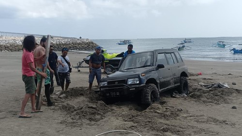 Mobil Suzuki Vitara berpelat AA 7310 DD terperosok di pasir Pantai Sekeh, Kuta, Badung, Bali, Kamis (18/5/2023).