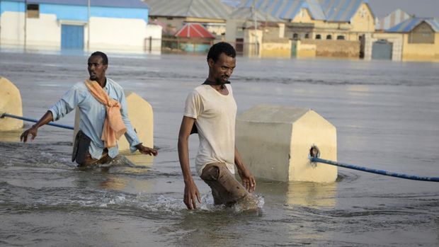 Orang-orang berjalan melewati banjir di sebuah jalan di kota Beledweyne, di Somalia Senin, 15 Mei 2023. Perkiraan dari Kantor PBB untuk Koordinasi Urusan Kemanusiaan adalah 460.000 orang terkena dampak banjir yang disebabkan oleh hujan lebat sejak pertengahan Maret. . (AP Photo)