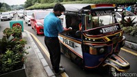 Selain mobil dan motor, ada juga warga yang datang dengan mengendarai bajaj. Kendaraan roda tiga itu terlihat antre bersama kendaraan roda empat.