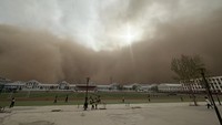 Wilayah Erenhot di Daerah Otonomi Mongolia Dalam, China, diterjang awan tebal dengan debu-debu oranye yang berterbangan.  