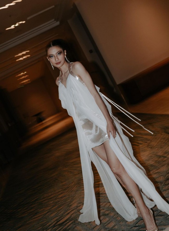 Mikha Tambayong memilih gaun after party dengan desain minimalis, resort, sensual, namun tetap kental nuansa pesta. Desainer Jeffry Tan pun menciptakan bikini dress putih yang dipercantik lapisan sifon draperi dan pita-pita mungil. Foto: Instagram/@jeffrytan