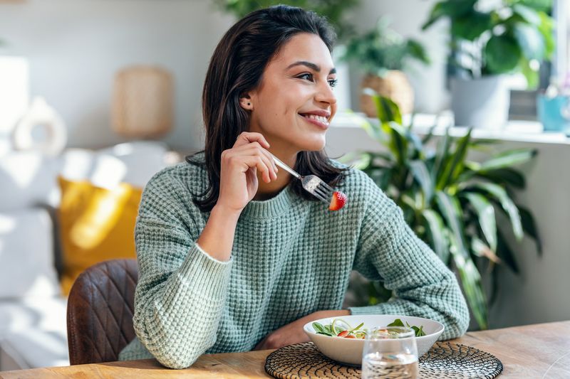 Ilustrasi wanita makan stroberi atau salad
