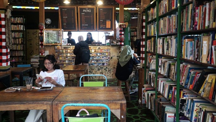 Kedai kopi berkonsep ruang baca Pengunjung menikmati minuman dengan membaca buku di Kedai Kopi Cafe Bukuku Lawas, Jebres, Solo, Jawa Tengah, Kamis (18/5/2023). Pelaku usaha mengkonsep kedai kopi miliknya dengan konsep ruang baca dan toko buku bekas untuk menarik pengunjung serta menyediakan literasi baca gratis bagi pelajar dan mahasiswa. ANTARA FOTO/Mohammad Ayudha/hp.