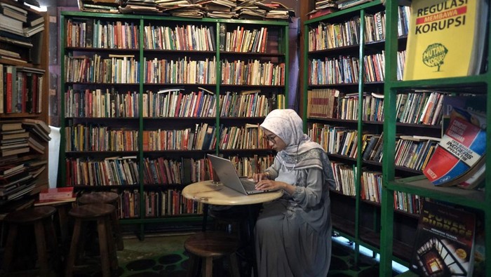 Pengunjung menikmati minuman dengan membaca buku di Kedai Kopi Cafe Bukuku Lawas, Jebres, Solo, Jawa Tengah, Kamis (18/5/2023). Pelaku usaha mengkonsep kedai kopi miliknya dengan konsep ruang baca dan toko buku bekas untuk menarik pengunjung serta menyediakan literasi baca gratis bagi pelajar dan mahasiswa. ANTARA FOTO/Mohammad Ayudha/hp.