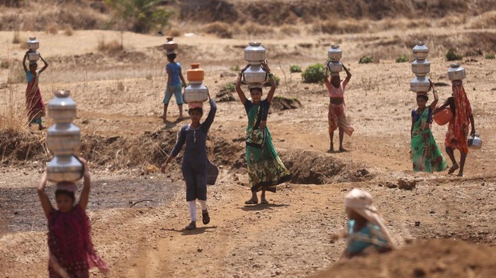 Musim Panas Bikin India Krisis Air Parah Women gather around a well to draw water from it in Telamwadi, near Mumbai, India, May 16, 2023. REUTERS/Francis Mascarenhas