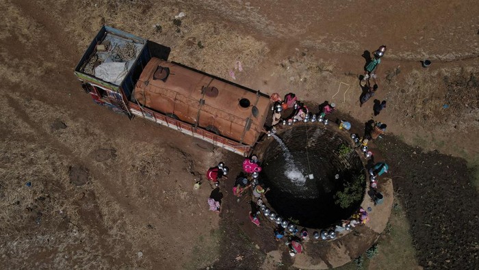 Musim Panas Bikin India Krisis Air Parah Women gather around a well to draw water from it in Telamwadi, near Mumbai, India, May 16, 2023. REUTERS/Francis Mascarenhas