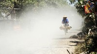 Warga mengayuh sepeda saat melintas di ruas jalan yang dalam proses perbaikan di Kabupaten Gowa, Sulawesi Selatan, Jumat (19/5/2023).