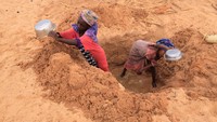 Gadis-gadis Sudan yang melarikan diri dari konflik di wilayah Darfur Sudan dan baru tiba, menggali sumur untuk mengambil air di dekat perbatasan antara Sudan dan Chad sambil mencari perlindungan di Goungour, Chad 12 Mei 2023.  