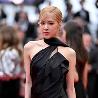 Penampilan Rose BLACKPINK di Festival Film Cannes membuat penggemar pangling dengan poni super pendek. Personel BLACKPINK itu memakai gaun hitam rancangan khusus Saint Laurent.  Foto: Getty Images