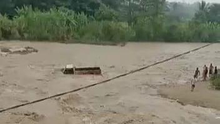 Truk hanyut terseret banjir bandang di Sungai Cibeet, Bogor, Jumat (19/5/2023) sore.