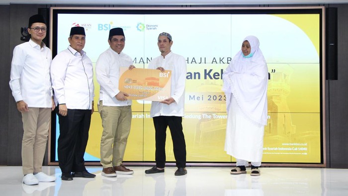165 Ribu Calon Jemaah Haji RI Bakal Ikut Manasik Akbar Direktur Sales & Distribution BSI Anton Sukarna (tengah) menyerahkan Kartu Debit Haji Indonesia kepada salah satu calon jemaah Haji Indonesia dari KBIH Al-Hasanah yang didampingi oleh Direktur Pengelolaan Dana Haji dan Sistem Informasi Haji Terpadu (Dirjen PHU) Kemenag Jaja Jaelani (kiri kedua) dan SVP Islamic Ecosystem BSI M. Syukron Habiby (kiri pertama) di tengah acara Manasik Akbar yang digelar di The Tower, Jakarta, Sabtu (20/5/2023).