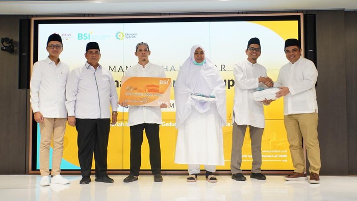 Direktur Sales & Distribution BSI Anton Sukarna (tengah) menyerahkan Kartu Debit Haji Indonesia kepada salah satu calon jemaah Haji Indonesia dari KBIH Al-Hasanah yang didampingi oleh Direktur Pengelolaan Dana Haji dan Sistem Informasi Haji Terpadu (Dirjen PHU) Kemenag Jaja Jaelani (kiri kedua) dan SVP Islamic Ecosystem BSI M. Syukron Habiby (kiri pertama) di tengah acara Manasik Akbar yang digelar di The Tower, Jakarta, Sabtu (20/5/2023).