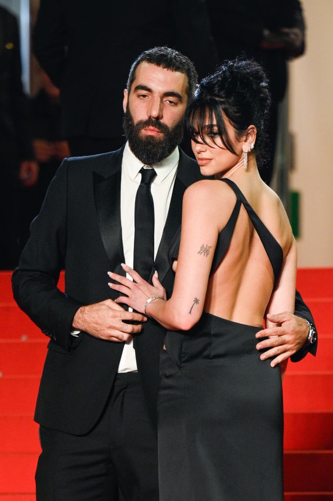 Serasi dengan sang kekasih, Romain Gavras juga memakai busana hitam berupa setelan jas yang dipadukan dengan kemeja putih. Foto: Stephane Cardinale/Corbis via Getty Images